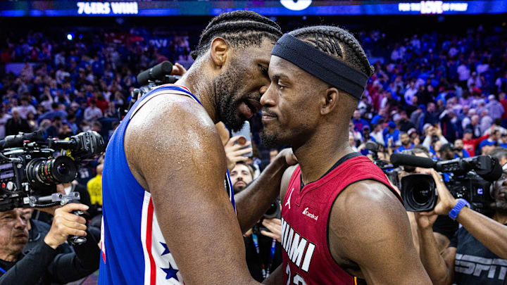 Apr 17, 2024; Philadelphia, Pennsylvania, USA; Philadelphia 76ers center Joel Embiid (21) hugs Miami Heat forward Jimmy Butler (22) on the court after a 76ers victory in a play-in game of the 2024 NBA playoffs at Wells Fargo Center. Mandatory Credit: Bill Streicher-USA TODAY Sports