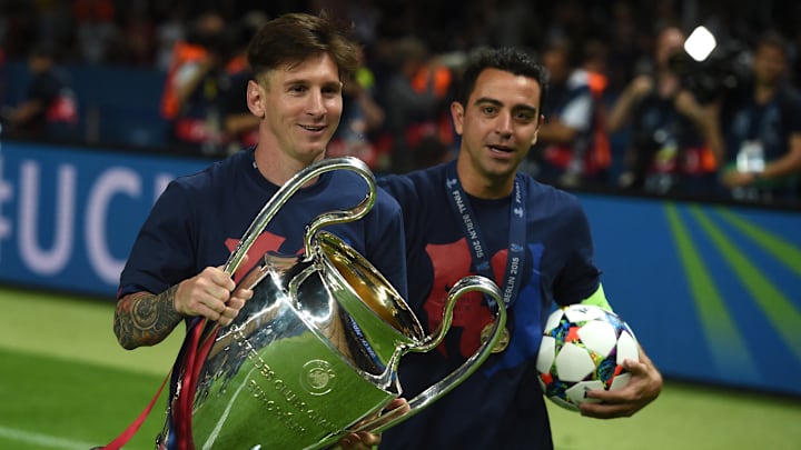 Lionel Messi y Xavi Hernández sosteniendo el trofeo de la Champions League, que ganaron por última vez en 2015