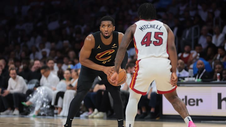 Apr 28, 2025; Miami, Florida, USA; Cleveland Cavaliers guard Donovan Mitchell (45) protects the basketball from Miami Heat guard Davion Mitchell (45) in the second quarter during game four for the first round of the 2025 NBA Playoffs at Kaseya Center. Mandatory Credit: Sam Navarro-Imagn Images