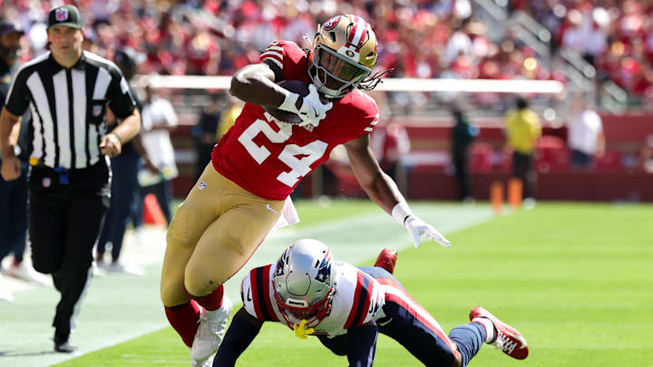 Sep 29, 2024; Santa Clara, California, USA; San Francisco 49ers running back Jordan Mason (24) is tackled by New England Patriots cornerback Christian Gonzalez (0) during the first quarter at Levi's Stadium. Mandatory Credit: Sergio Estrada-Imagn Images