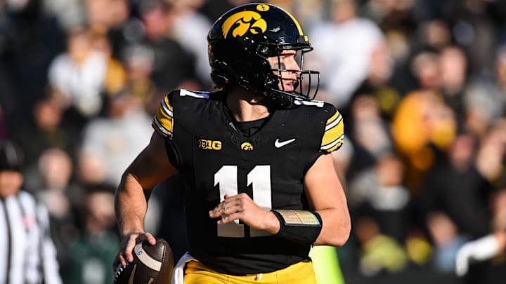 Nov 22, 2025; Iowa City, Iowa, USA; Iowa Hawkeyes quarterback Mark Gronowski (11) rolls out to throws a pass against the Michigan State Spartans during the first quarter at Kinnick Stadium. Mandatory Credit: Jeffrey Becker-Imagn Images
