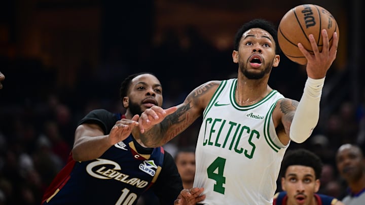 Nov 30, 2025; Cleveland, Ohio, USA; Boston Celtics guard Anfernee Simons (4) goes to the basket, Cleveland Cavaliers guard Darius Garland (10) during the first half at Rocket Arena.