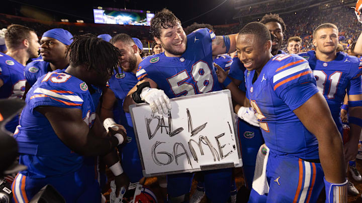 Florida Gators offensive lineman Austin Barber (58) pulls in Florida Gators quarterback DJ Lagway (2) as the Gators celebrated at Ben Hill Griffin Stadium in Gainesville, FL on Saturday, November 16, 2024. The Gators defeated the Tigers 27-16. [Doug Engle/Gainesville Sun]