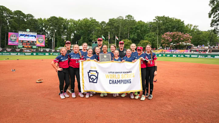 2025 Little League Softball World Series Champions West Suburban LL out of Pennsylvania pose for a photo with their trophy and championship banner.