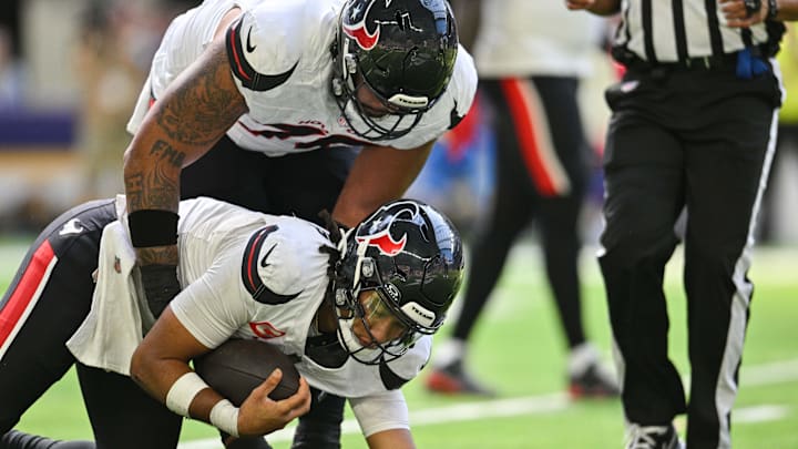 Sep 22, 2024; Minneapolis, Minnesota, USA; Houston Texans center Juice Scruggs (70) helps quarterback C.J. Stroud (7) off the field after a sack during the second quarter against the Minnesota Vikings at U.S. Bank Stadium. Mandatory Credit: Jeffrey Becker-Imagn Images