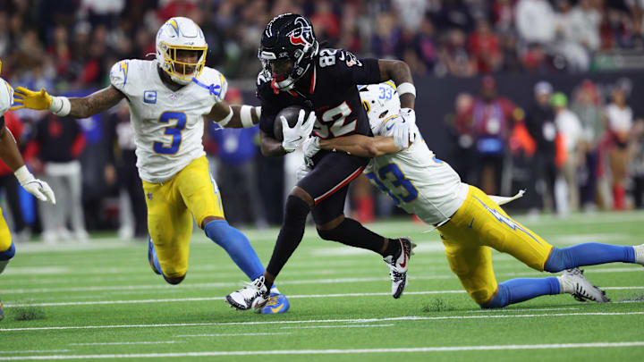 Jan 11, 2025; Houston, Texas, USA; Houston Texans wide receiver Diontae Johnson (82) runs the ball after a reception against Los Angeles Chargers defensive back Deane Leonard (33) and safety Derwin Jarnes Jr. (3) during the third quarter in an AFC wild card game at NRG Stadium.