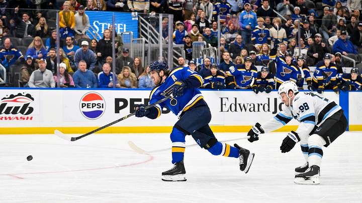 Nov 29, 2025; St. Louis, Missouri, USA; St. Louis Blues center Robert Thomas (18) shoots as Utah Mammoth defenseman Mikhail Sergachev (98) defends during the second period at Enterprise Center. Mandatory Credit: Jeff Curry-Imagn Images
