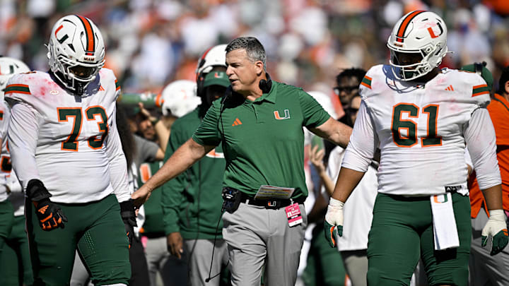 Nov 1, 2025; Dallas, Texas, USA;  Miami Hurricanes head coach Mario Cristobal talks to offensive lineman Anez Cooper (73) and offensive lineman Francis Mauigoa (61) during the second half against the SMU Mustangs at Gerald J. Ford Stadium. Mandatory Credit: Jerome Miron-Imagn Images