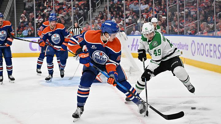 Nov 25, 2025; Edmonton, Alberta, CAN;  Edmonton Oilers centre Connor Clattenburg (64) chases the puck with Dallas Stars centre Justin Hryckowian (49) during the second period at Rogers Place. Mandatory Credit: Walter Tychnowicz-Imagn Images