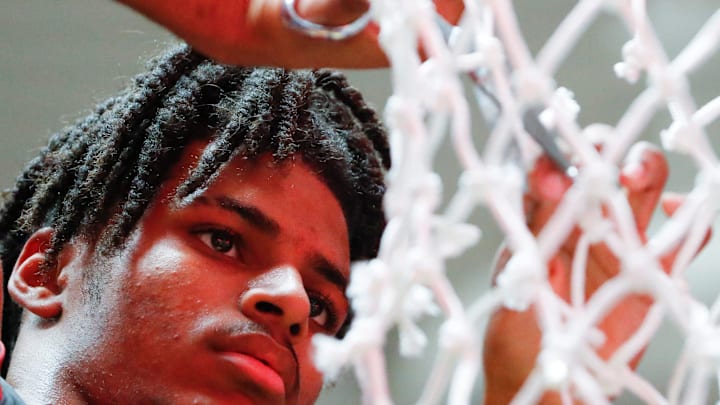 Fishers Tigers Jason Gardner (5) cuts down the net Saturday, March 15, 2025, after the IHSAA boys basketball 4A regional championship game against the Harrison Raiders at Frankfort High School in Frankfort, Ind. Fishers won 89-39.