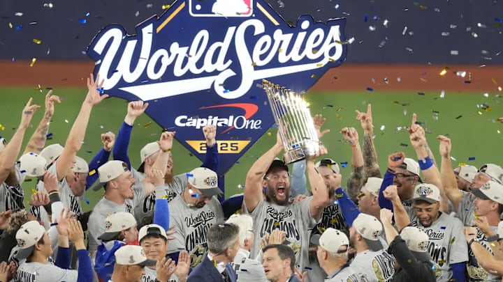 Nov 1, 2025; Toronto, Ontario, CAN; Los Angeles Dodgers pitcher Clayton Kershaw (22) celebrates with the Commissioner's Trophy after defeating the Toronto Blue Jays in game seven of the 2025 MLB World Series at Rogers Centre. Mandatory Credit: Kevin Sousa-Imagn Images