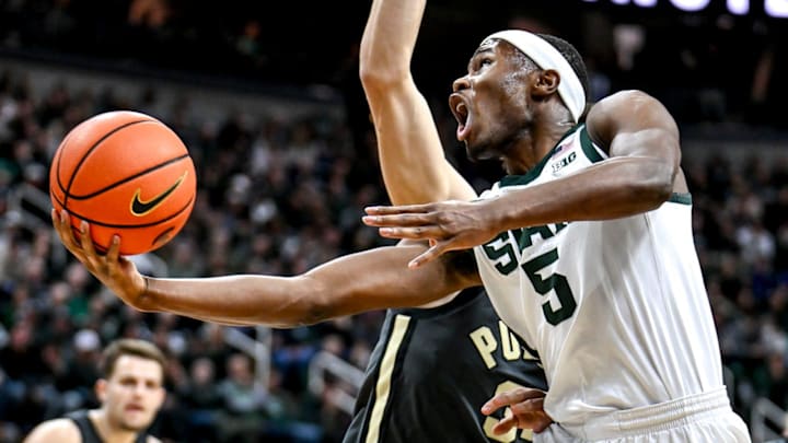 Michigan State's Tre Holloman scores and is fouled by Purdue's Raleigh Burgess during the first half on Tuesday, Feb. 18, 2025, at the Breslin Center in East Lansing.