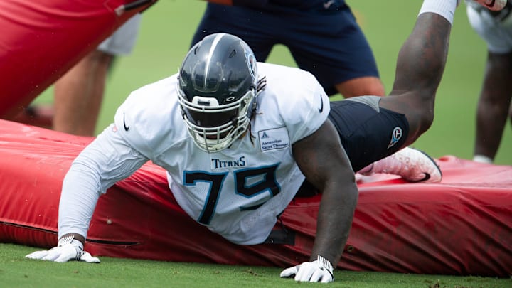 Tennessee Titans tackle Isaiah Wilson slides off a  pad during tackling drills