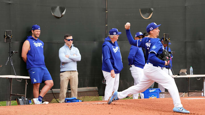 Feb 12, 2025; Glendale, AZ, USA; Los Angeles Dodgers pitcher Blake Snell (7) throws as pitcher Clayton Kershaw (left) looks on during a Spring Training workout at Camelback Ranch. Mandatory Credit: Joe Camporeale-Imagn Images