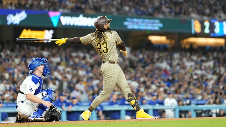 Sep 25, 2024; Los Angeles, California, USA; San Diego Padres right fielder Fernando Tatis Jr. (23) hits a solo home run in the fifth inning as Los Angeles Dodgers catcher Will Smith (16) watches at Dodger Stadium. Sep 25, 2024; Los Angeles, California, USA; San Diego Padres right fielder Fernando Tatis Jr. (23) hits a solo home run in the fifth inning as Los Angeles Dodgers catcher Will Smith (16) watches at Dodger Stadium.