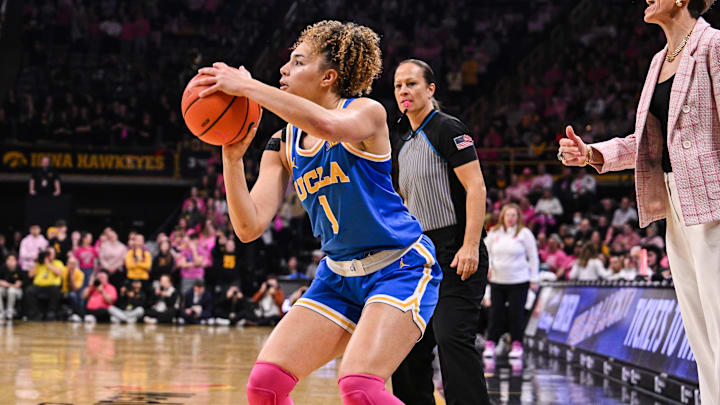 Feb 23, 2025; Iowa City, Iowa, USA; UCLA Bruins guard Kiki Rice (1) shoots the ball as Iowa Hawkeyes head coach Jan Jensen looks on during the second quarter at Carver-Hawkeye Arena. Mandatory Credit: Jeffrey Becker-Imagn Images Feb 23, 2025; Iowa City, Iowa, USA; UCLA Bruins guard Kiki Rice (1) shoots the ball as Iowa Hawkeyes head coach Jan Jensen looks on during the second quarter at Carver-Hawkeye Arena. Mandatory Credit: Jeffrey Becker-Imagn Images