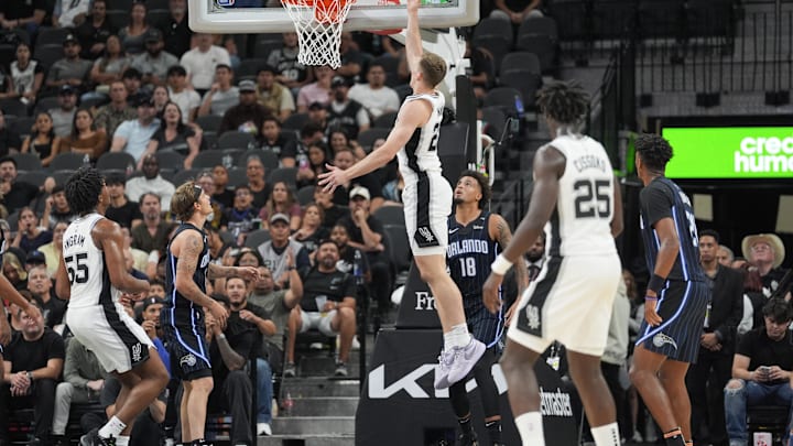 Oct 9, 2024; San Antonio, Texas, USA;  San Antonio Spurs forward Riley Minix (27) goes up over Orlando Magic forward Jalen Slawson (18) in the second half at Frost Bank Center. Mandatory Credit: Daniel Dunn-Imagn Images
