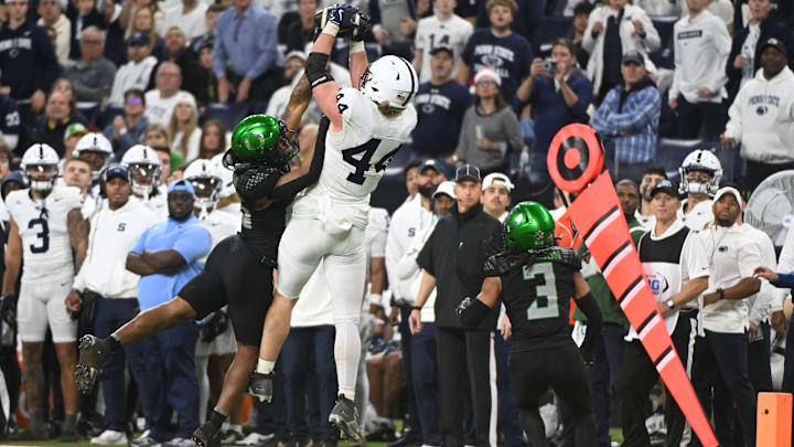 Penn State Nittany Lions tight end Tyler Warren (44) catches a pass over the head of Oregon Ducks linebacker Devon Jackson (26) during the third quarter in the 2024 Big Ten Championship game at Lucas Oil Stadium. 
