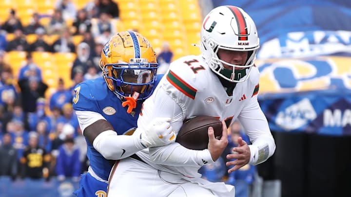 Nov 29, 2025; Pittsburgh, Pennsylvania, USA;  Miami Hurricanes quarterback Carson Beck (11) runs the ball as Pittsburgh Panthers linebacker Rasheem Biles (3) tackles during the first quarter at Acrisure Stadium. Mandatory Credit: Charles LeClaire-Imagn Images