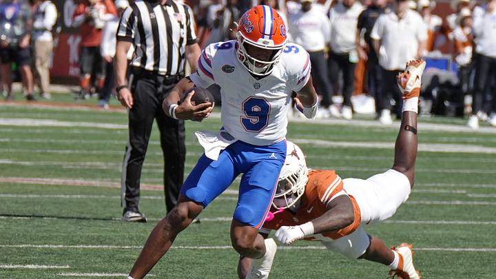 Florida Gators quarterback Tramell Jones Jr.  escapes a tackle from Texas Longhorns linebacker Rasheem Biles during the first half