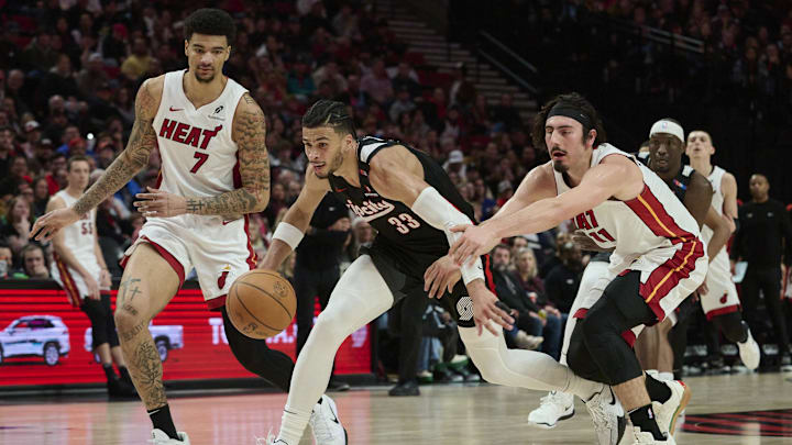 Jan 11, 2025; Portland, Oregon, USA; Portland Trail Blazers forward Toumani Camara (33) controls a loose ball during the second half against Miami Heat guard Jaime Jaquez Jr. (11) and center Kel'el Ware (7) at Moda Center. Mandatory Credit: Troy Wayrynen-Imagn Images
