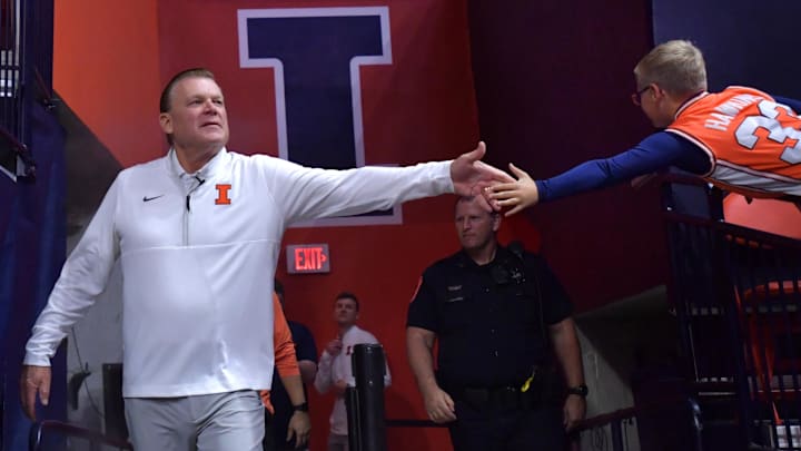 Nov 4, 2024; Champaign, Illinois, USA;  Illinois Fighting Illini head coach Brad Underwood gets a hand from a young fan before a game against the Eastern Illinois Panthers at State Farm Center. Mandatory Credit: Ron Johnson-Imagn Images