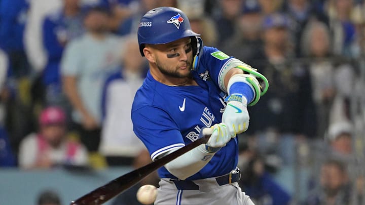 Oct 27, 2025; Los Angeles, California, USA; Toronto Blue Jays second baseman Bo Bichette (11) hits an RBI single against the Los Angeles Dodgers in the seventh inning during game three of the 2025 MLB World Series at Dodger Stadium. Mandatory Credit: Jayne Kamin-Oncea-Imagn Images
