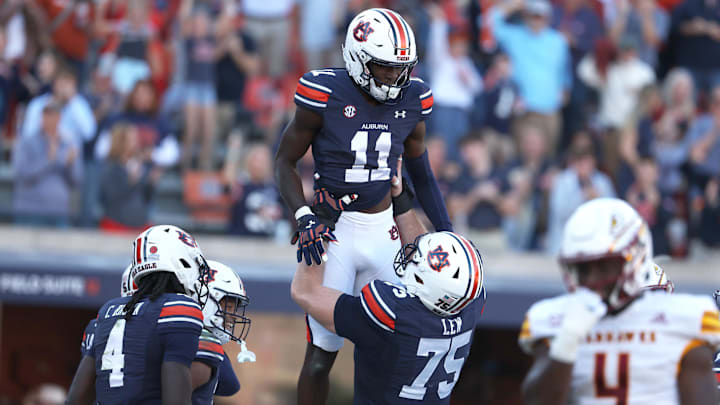 Nov 16, 2024; Auburn, Alabama, USA;  Auburn Tigers receiver Malcom Simmons (11) celebrates with offensive lineman Connor Lew (75) after scoring a touchdown against the Louisiana Monroe Warhawks in the third quarter at Jordan-Hare Stadium.  Mandatory Credit: John Reed-Imagn Images