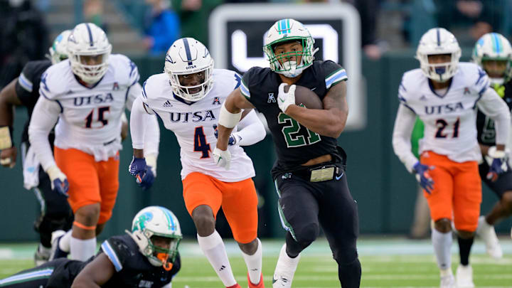 Nov 24, 2023; New Orleans, Louisiana, USA; Tulane Green Wave running back Makhi Hughes (21) runs against UTSA Roadrunners running back Kevorian Barnes (4) during the first half at Yulman Stadium.