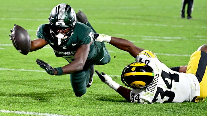 Oct 19, 2024; East Lansing, Michigan, USA;  Michigan State Spartans wide receiver Nick Marsh (6) reaches for the goal line as he is hit by Iowa Hawkeyes linebacker Jay Higgins (34) and is ruled down just short of the goal line in the fourth quarter at Spartan Stadium. Mandatory Credit: Dale Young-Imagn Images