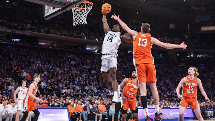 Feb 22, 2025; New York, NY, USA; Duke Blue Devils guard Sion James (14) drives past Illinois Fighting Illini center Tomislav Ivisic (13) for a dunk attempt in the first half at Madison Square Garden. Mandatory Credit: Wendell Cruz-Imagn Images