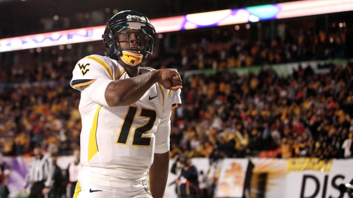 Jan 4, 2012; Miami Gardens, FL, USA; West Virginia Mountaineers quarterback Geno Smith (12) celebrates after the Mountaineers scored a touchdown during the third quarter of the 2012 Orange Bowl game against the Clemson Tigers at Sun Life Stadium. Mountaineers won 70 to 33. Mandatory Credit: Joshua S. Kelly-USA TODAY Sports