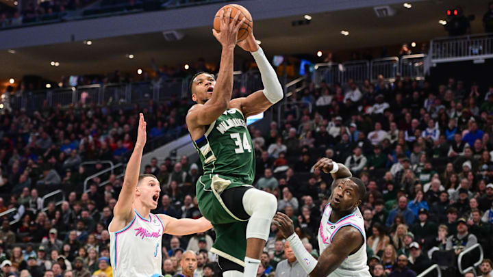 Jan 23, 2025; Milwaukee, Wisconsin, USA; Milwaukee Bucks forward Giannis Antetokounmpo (34) takes a shot between Miami Heat forward Nikola Jovic (5) and guard Terry Rozier (2) in the second quarter at Fiserv Forum. Mandatory Credit: Benny Sieu-Imagn Images