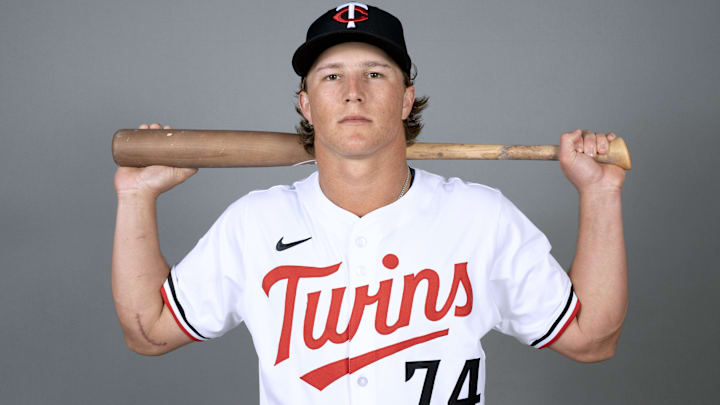 Twins prospect Luke Keaschall shows off the Tommy John surgery scar on his right elbow as he poses for a picture with his bat during Spring Training 2005.  