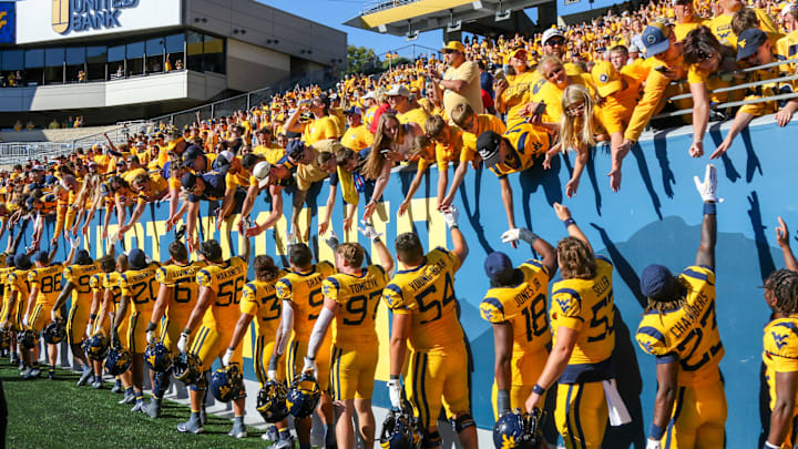 Aug 30, 2025; Morgantown, West Virginia, USA; West Virginia Mountaineers fans celebrate with players after defeating the Robert Morris Colonials at Milan Puskar Stadium. Mandatory Credit: Ben Queen-Imagn Images