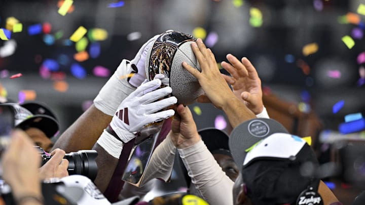 Dec 7, 2024; Arlington, TX, USA; The Arizona State Sun Devils team celebrate with the trophy after the Sun Devils defeat the Iowa State Cyclones and win the 2024 Big 12 Championship at AT&T Stadium. Mandatory Credit: Jerome Miron-Imagn Images Dec 7, 2024; Arlington, TX, USA; The Arizona State Sun Devils team celebrate with the trophy after the Sun Devils defeat the Iowa State Cyclones and win the 2024 Big 12 Championship at AT&T Stadium. Mandatory Credit: Jerome Miron-Imagn Images