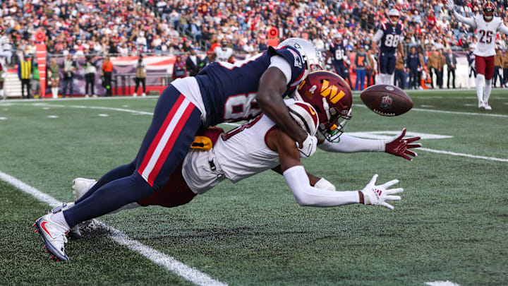 Nov 5, 2023; Foxborough, Massachusetts, USA; Washington Commanders cornerback Emmanuel Forbes (13) breaks up a pass to New England Patriots receiver Jalen Reagor (83) during the second half at Gillette Stadium. Mandatory Credit: Paul Rutherford-Imagn Images