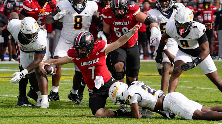 Dec 23, 2025; Boca Raton, FL, USA; Louisville Cardinals quarterback Miller Moss (7) reaches for a first down against the Toledo Rockets in the first quarter at Flagler CU Stadium. Mandatory Credit: Jeff Romance-Imagn Images