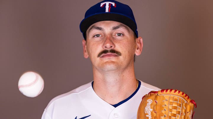 Texas Rangers pitcher Peyton Gray poses for a photo while tossing a baseball. 
