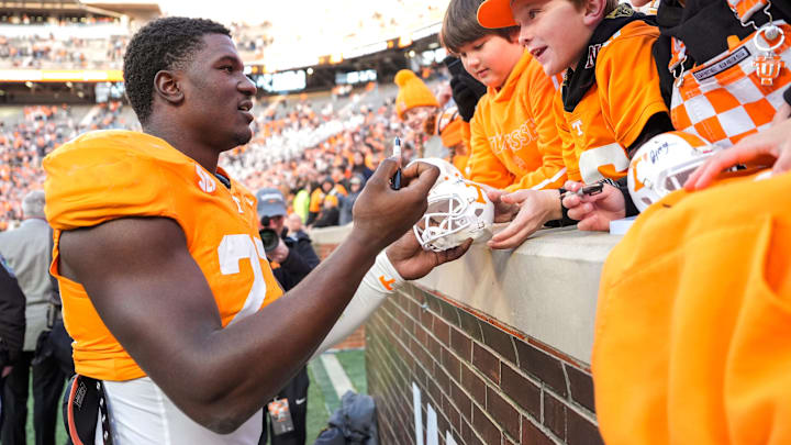 Nov 23, 2024; Knoxville, Tennessee, USA; Tennessee Volunteers defensive lineman James Pearce Jr. (27) autographs items for childrenafter a game against the UTEP Miners at Neyland Stadium. Mandatory Credit: Brianna Paciorka/USA TODAY Network via Imagn Images Nov 23, 2024; Knoxville, Tennessee, USA; Tennessee Volunteers defensive lineman James Pearce Jr. (27) autographs items for childrenafter a game against the UTEP Miners at Neyland Stadium. Mandatory Credit: Brianna Paciorka/USA TODAY Network via Imagn Images