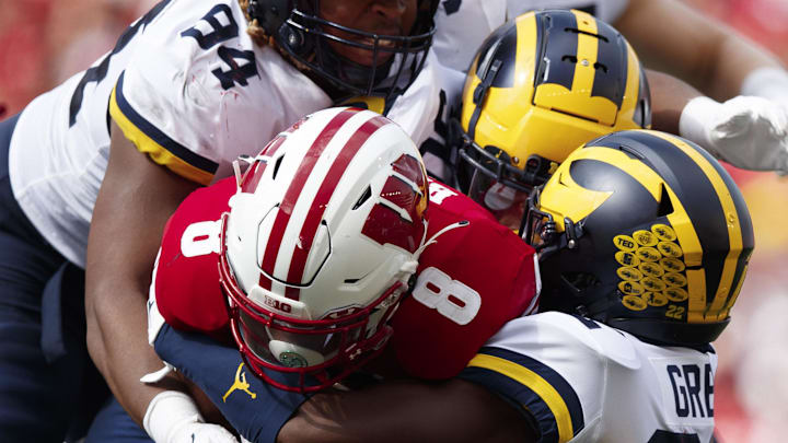 Oct 2, 2021; Madison, Wisconsin, USA; Wisconsin Badgers running back Jalen Berger (8) is tackled by Michigan Wolverines defensive back Gemon Green (22) and defensive end Gio Paez (94) during the third quarter at Camp Randall Stadium. Oct 2, 2021; Madison, Wisconsin, USA; Wisconsin Badgers running back Jalen Berger (8) is tackled by Michigan Wolverines defensive back Gemon Green (22) and defensive end Gio Paez (94) during the third quarter at Camp Randall Stadium.