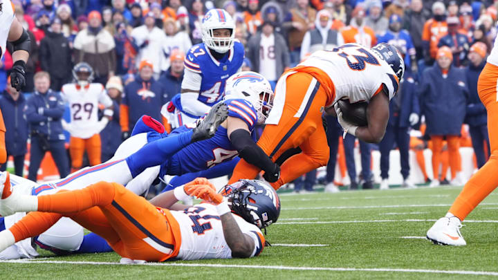 Jan 12, 2025; Orchard Park, New York, USA; Denver Broncos running back Javonte Williams (33) is tackled by Buffalo Bills linebacker Terrel Bernard (43) during the first quarter in an AFC wild card game at Highmark Stadium.