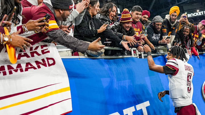 Washington Commanders quarterback Jayden Daniels shakes hands and high-fives fans after defeating the Detroit Lions 45-31 in the NFC divisional round playoff game at Ford Field in Detroit, Saturday, Jan. 18, 2025.