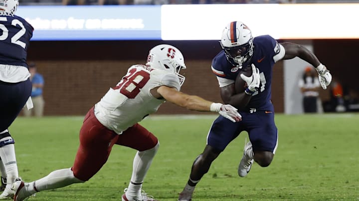 Sep 20, 2025; Charlottesville, Virginia, USA; Virginia Cavaliers running back Harrison Waylee (21) carries the ball as Stanford Cardinal linebacker Zach Johnson (38) attempts a tackle during the fourth quarter at Scott Stadium. Mandatory Credit: Geoff Burke-Imagn Images Sep 20, 2025; Charlottesville, Virginia, USA; Virginia Cavaliers running back Harrison Waylee (21) carries the ball as Stanford Cardinal linebacker Zach Johnson (38) attempts a tackle during the fourth quarter at Scott Stadium. Mandatory Credit: Geoff Burke-Imagn Images
