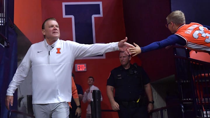 Nov 4, 2024; Champaign, Illinois, USA;  Illinois Fighting Illini head coach Brad Underwood gets a hand from a young fan before a game against the Eastern Illinois Panthers at State Farm Center. Mandatory Credit: Ron Johnson-Imagn Images