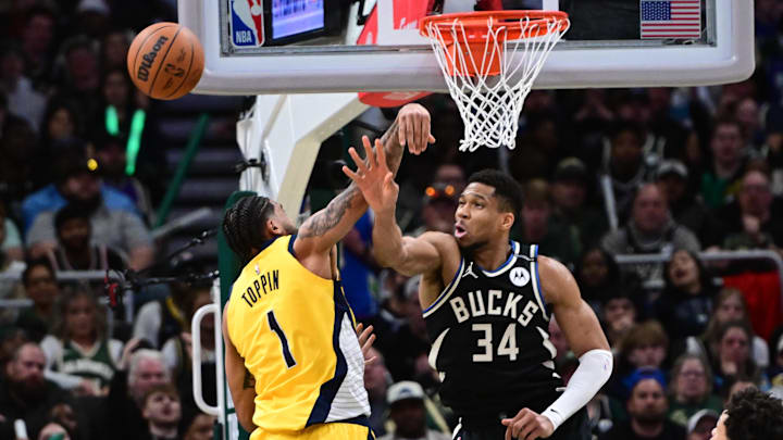 Apr 27, 2025; Milwaukee, Wisconsin, USA; Milwaukee Bucks forward Giannis Antetokounmpo (34) and Indiana Pacers forward Obi Toppin (1) reach for the ball in the third quarter during game four of first round for the 2024 NBA Playoffs at Fiserv Forum. Mandatory Credit: Benny Sieu-Imagn Images