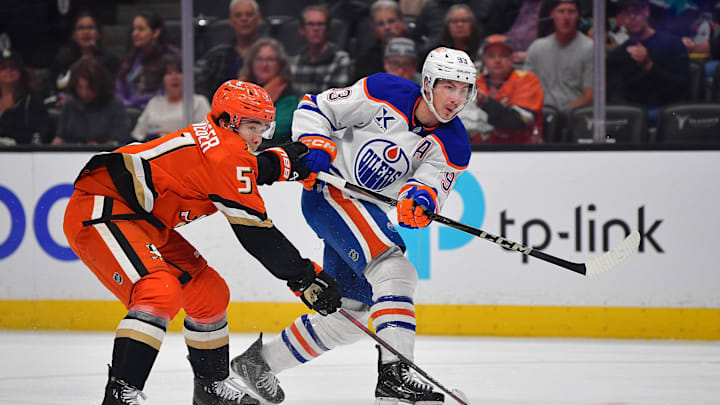 Apr 7, 2025; Anaheim, California, USA; Edmonton Oilers center Ryan Nugent-Hopkins (93) shoots against Anaheim Ducks defenseman Olen Zellweger (51) during the first period at Honda Center. Mandatory Credit: Gary A. Vasquez-Imagn Images