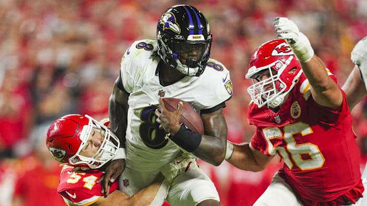 Baltimore Ravens quarterback Lamar Jackson is tackled by Kansas City Chiefs defenders Leo Chenal and George Karlaftis.