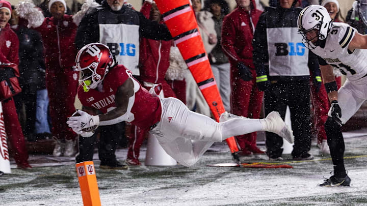 Nov 30, 2024; Bloomington, Indiana, USA;  Indiana Hoosiers running back Justice Ellison (6) runs the ball while Purdue Boilermakers defensive back Dillon Thieneman (31) defends in the first quarter at Memorial Stadium. Mandatory Credit: Trevor Ruszkowski-Imagn Images