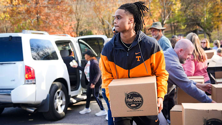Tennessee defensive back Colin Brazzell loads a box of canned goods into a vehicle during a mobile food pantry at Tabernacle Missionary Baptist Church in East Knoxville on Nov. 13, 2025. Brazzell, his brother Chris Brazzell and their parents joined volunteers from Tabernacle Missionary Baptist Church and Second Harvest Food Bank of East Tennessee to distribute 38,040 pounds of food to more than 600 families on Thursday.